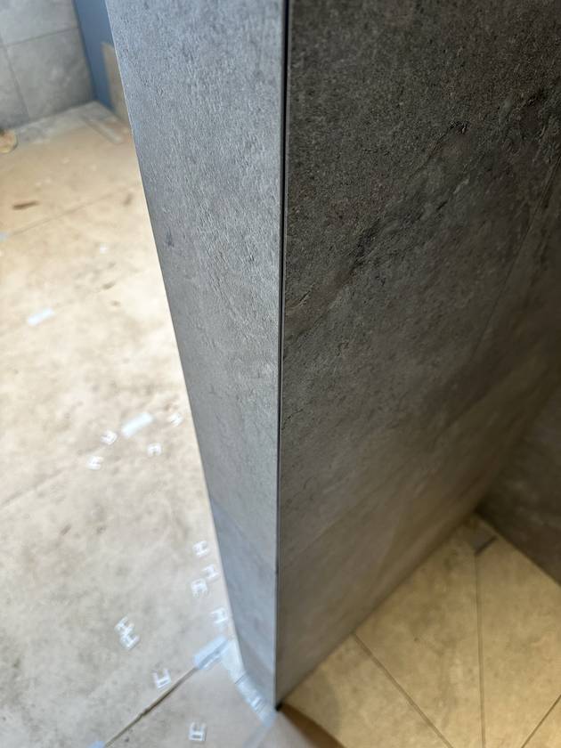 Mitred corner: Both edges cut at 45°. Solid tile all the way round, no metal strip.