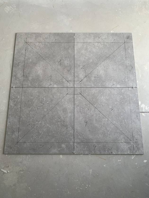 Set out before the cut: Each shower floor tile is marked and numbered for the fall before it is cut.